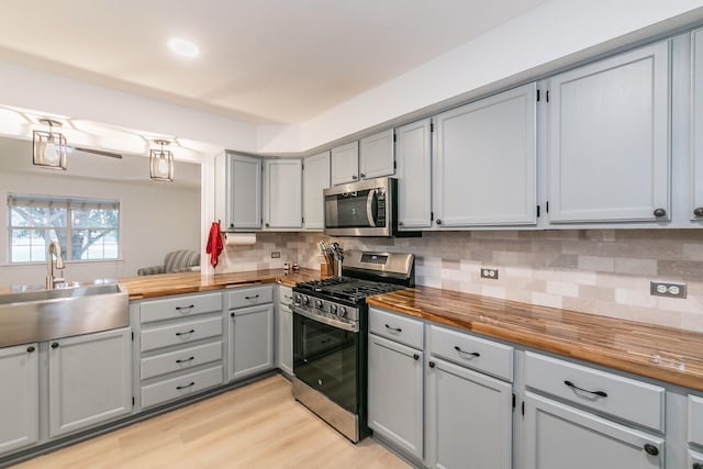1503 County Road 705, Joshua, TX 76058 - kitchen featuring appliances with stainless steel finishes, gray cabinetry, a sink, and butcher block countertops