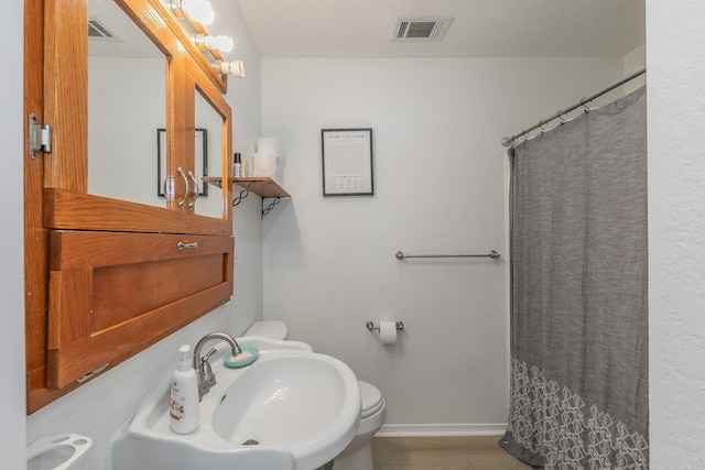 1503 County Road 705, Joshua, TX 76058 - bathroom featuring baseboards, a sink, toilet, and curtained shower