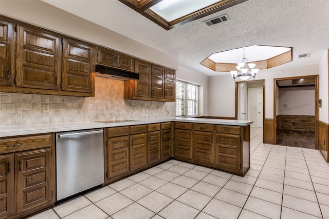 1504 Huron Trl, Plano, TX 75075 - kitchen featuring stainless steel dishwasher, light countertops, a chandelier, under cabinet range hood, and a peninsula