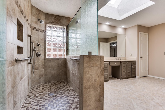 1504 Huron Trl, Plano, TX 75075 - bathroom featuring tiled shower, vanity, a skylight, tile patterned flooring, and a textured ceiling
