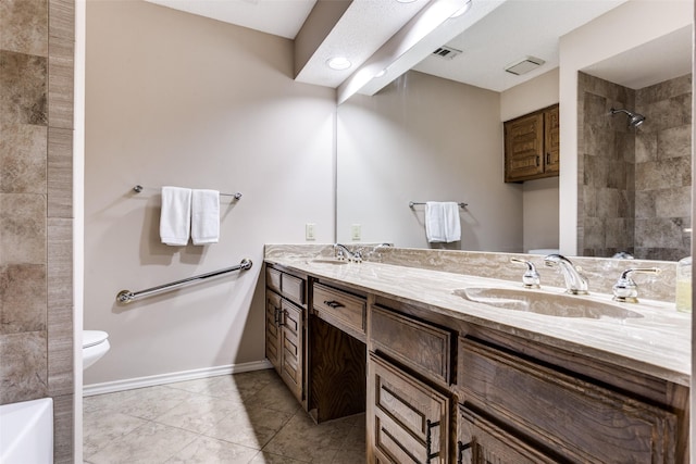 1504 Huron Trl, Plano, TX 75075 - full bathroom featuring double vanity, toilet, baseboards, a tile shower, and tile patterned flooring