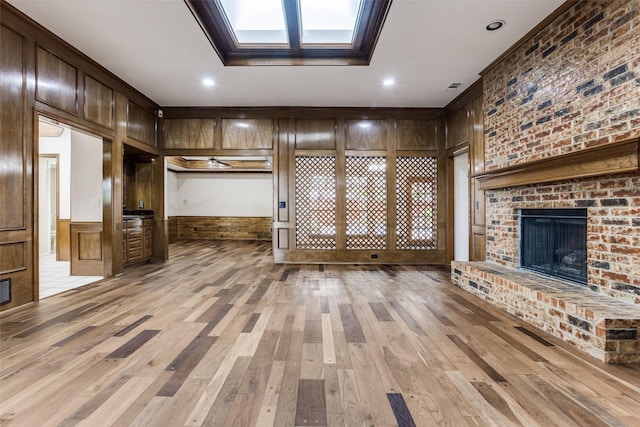 1504 Huron Trl, Plano, TX 75075 - unfurnished living room with a fireplace, ornamental molding, light wood-style flooring, wood walls, and recessed lighting