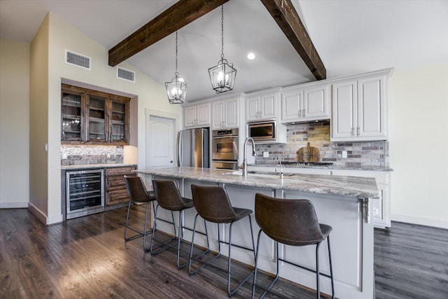523 Contour Dr, Granite Shoals, TX 78654 - kitchen featuring wine cooler, appliances with stainless steel finishes, backsplash, a kitchen bar, and glass insert cabinets