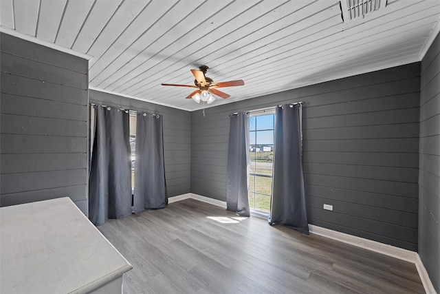738 Randy Dr, Woodway, TX 76712 - empty room with baseboards, ceiling fan, wood finished floors, wood ceiling, and wooden walls