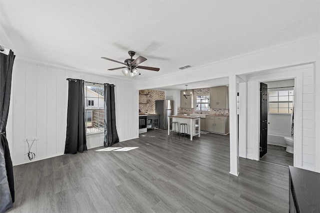 738 Randy Dr, Woodway, TX 76712 - unfurnished living room with ceiling fan, dark wood-style floors, and a chandelier