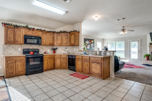 2101 Thistle Ln, Forney, TX 75126 - kitchen with black appliances, a peninsula, light countertops, open floor plan, and brown cabinetry