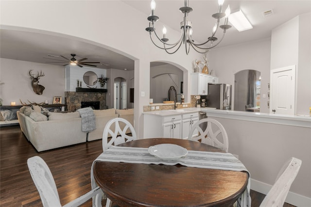 3659 Smoketree Dr, Rockwall, TX 75032 - dining area featuring ceiling fan, a chandelier, dark wood finished floors, and a fireplace