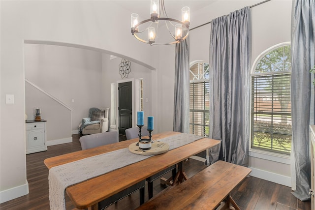 3659 Smoketree Dr, Rockwall, TX 75032 - dining space with a chandelier, healthy amount of natural light, a towering ceiling, arched walkways, and wood finished floors