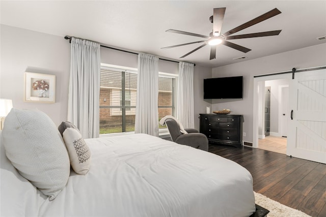 3659 Smoketree Dr, Rockwall, TX 75032 - bedroom with a barn door, dark wood finished floors, and ceiling fan