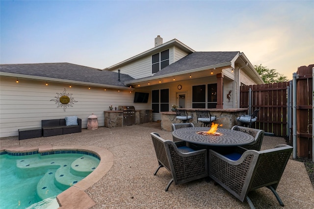 3659 Smoketree Dr, Rockwall, TX 75032 - back of house with a fire pit, a patio area, a chimney, exterior kitchen, and a shingled roof