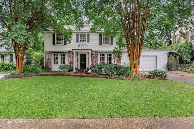 517 Ratcliff St, Shreveport, LA 71104 - view of front facade featuring a garage, driveway, a front yard, and brick siding