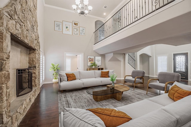 3313 Country Club Rd, Pantego, TX 76013 - living area with a stone fireplace, hardwood / wood-style floors, crown molding, a towering ceiling, and arched walkways
