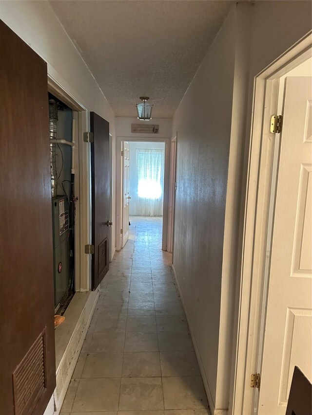 2410 Asbury St, Brownwood, TX 76801 - hall featuring light tile patterned flooring and a textured ceiling