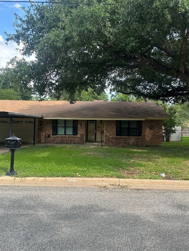 2410 Asbury St, Brownwood, TX 76801 - ranch-style home featuring a garage, a front lawn, brick siding, and driveway