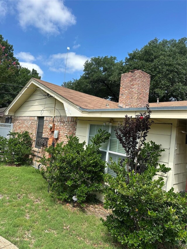 2410 Asbury St, Brownwood, TX 76801 - view of side of property with a chimney, a yard, and brick siding