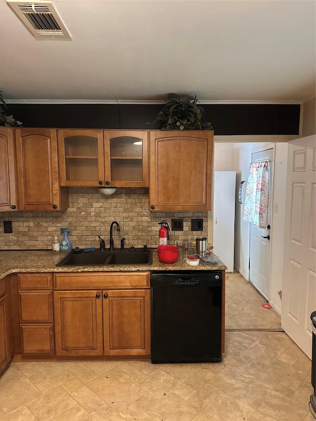2410 Asbury St, Brownwood, TX 76801 - kitchen with black dishwasher, a sink, brown cabinets, and backsplash