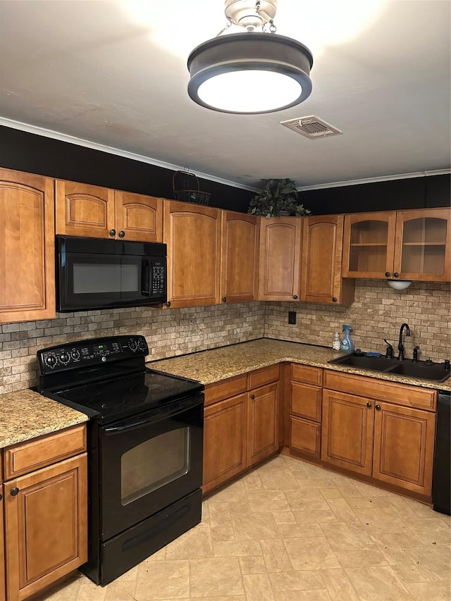 2410 Asbury St, Brownwood, TX 76801 - kitchen featuring black appliances, a sink, brown cabinets, and ornamental molding