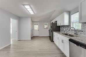 128 Stephens St, Waxahachie, TX 75165 - kitchen featuring stainless steel appliances, a sink, tasteful backsplash, baseboards, and light wood-style floors
