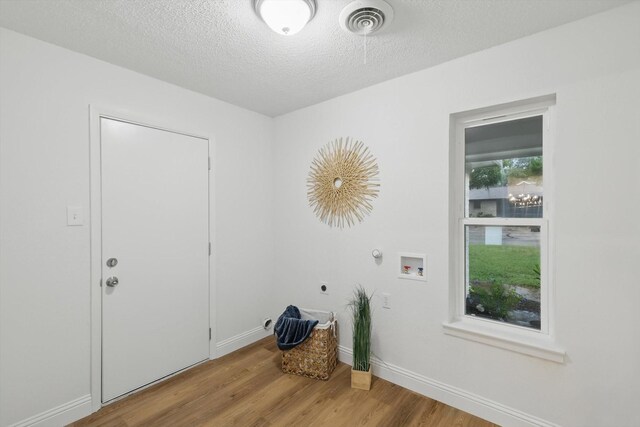 6304 Circleview Dr, Haltom City, TX 76180 - laundry area featuring electric dryer hookup, wood finished floors, a textured ceiling, gas dryer hookup, and hookup for a washing machine