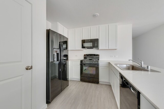 7712 Reese St, Dallas, TX 75114 - kitchen with black appliances, a sink, light wood-style floors, and light countertops