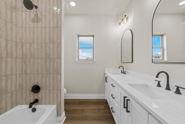 10917 Granada Dr, Waco, TX 76708 - bathroom with double vanity, toilet, wood finished floors, and plenty of natural light