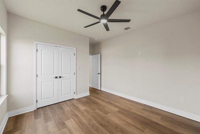 10917 Granada Dr, Waco, TX 76708 - unfurnished bedroom with wood finished floors, baseboards, a closet, and a ceiling fan