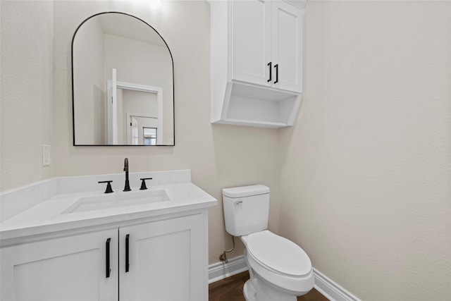 10917 Granada Dr, Waco, TX 76708 - bathroom featuring toilet, vanity, baseboards, and wood finished floors