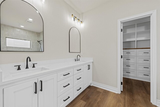 10917 Granada Dr, Waco, TX 76708 - full bathroom with double vanity, wood finished floors, a spacious closet, and baseboards