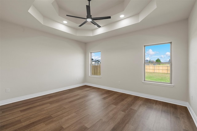 10917 Granada Dr, Waco, TX 76708 - unfurnished room featuring a tray ceiling, ceiling fan, dark wood-style floors, plenty of natural light, and recessed lighting