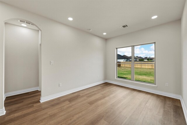 10917 Granada Dr, Waco, TX 76708 - unfurnished room with wood finished floors, arched walkways, recessed lighting, and baseboards