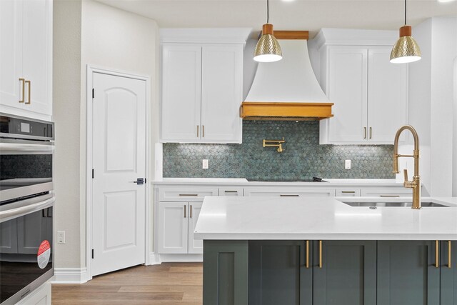 10917 Granada Dr, Waco, TX 76708 - kitchen featuring a sink, stainless steel double oven, custom range hood, and light countertops