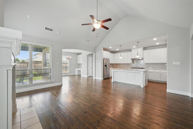 2004 Long Park Ave, Prosper, TX 75078 - unfurnished living room with high vaulted ceiling, ceiling fan, arched walkways, dark wood-style flooring, and a sink