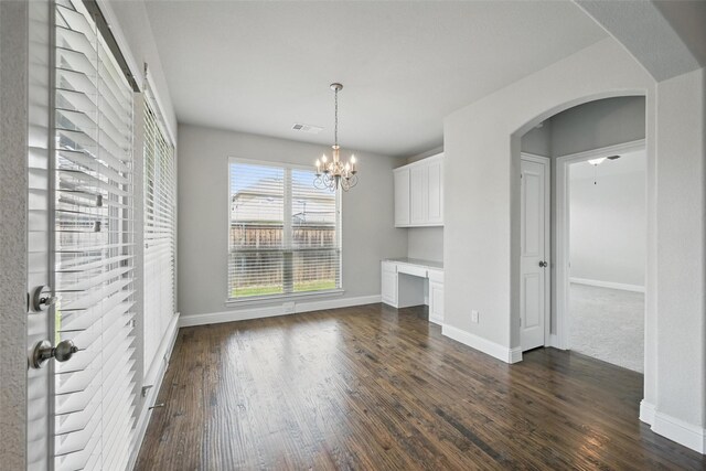 2004 Long Park Ave, Prosper, TX 75078 - unfurnished dining area featuring arched walkways, baseboards, dark wood-style floors, and a chandelier