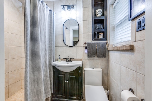 605 Devonshire Dr, Richardson, TX 75080 - bathroom featuring tile walls, toilet, tiled shower, and vanity