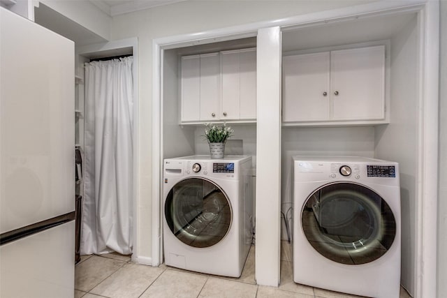 605 Devonshire Dr, Richardson, TX 75080 - laundry room with washer and clothes dryer, light tile patterned flooring, crown molding, and cabinet space