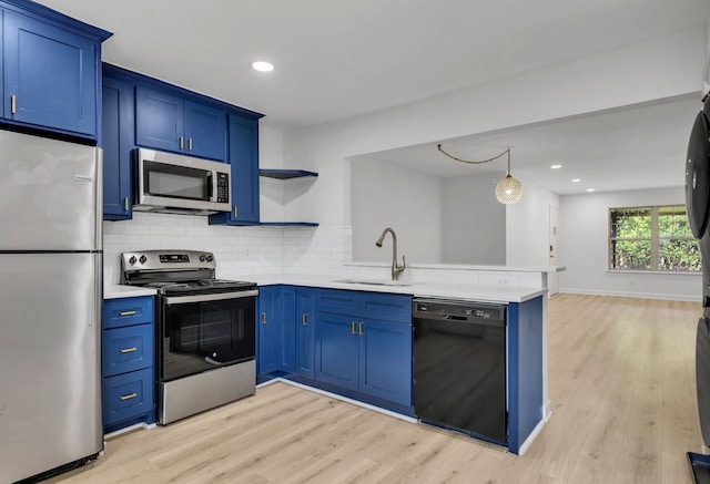 7718 Royal Ln Unit 214, Dallas, TX 75230 - kitchen featuring appliances with stainless steel finishes, blue cabinetry, a sink, a peninsula, and recessed lighting