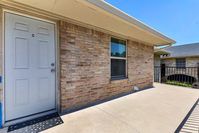 7718 Royal Ln Unit 214, Dallas, TX 75230 - view of exterior entry featuring brick siding and a patio area