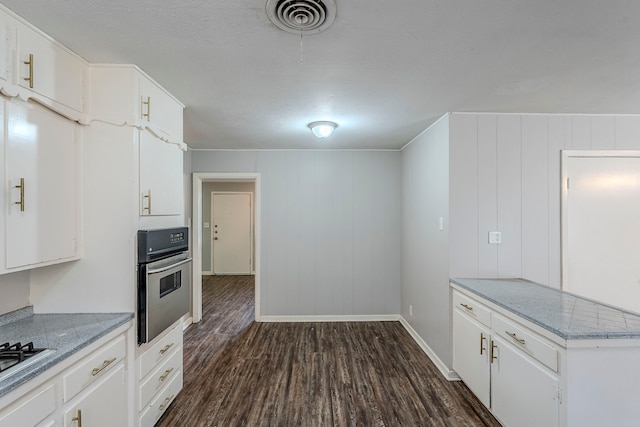 5729 Wales Ave, Fort Worth, TX 76133 - kitchen with appliances with stainless steel finishes, dark wood-type flooring, white cabinetry, baseboards, and light stone counters