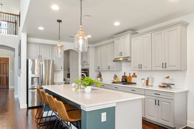 1008 Cason Falls Rd, Mckinney, TX 75071 - kitchen featuring stainless steel appliances, arched walkways, a sink, recessed lighting, and under cabinet range hood