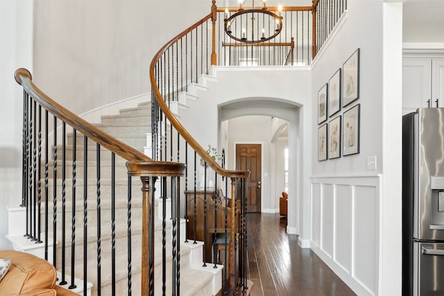 1008 Cason Falls Rd, Mckinney, TX 75071 - entryway with arched walkways, dark wood-type flooring, a chandelier, stairs, and a high ceiling