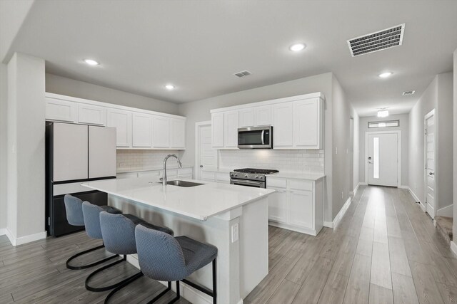 2321 Spring Side Dr, Royse City, TX 75189 - kitchen featuring a sink, appliances with stainless steel finishes, backsplash, white cabinets, and baseboards