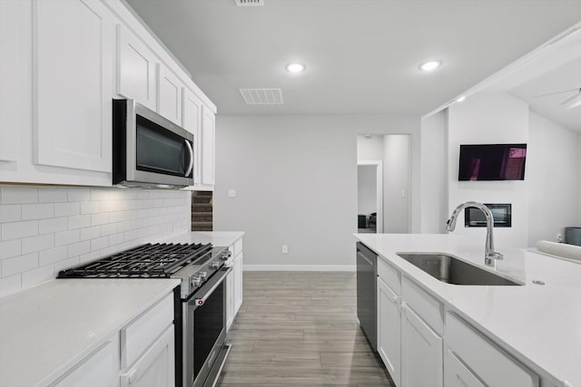 2321 Spring Side Dr, Royse City, TX 75189 - kitchen featuring appliances with stainless steel finishes, a sink, light wood finished floors, baseboards, and tasteful backsplash