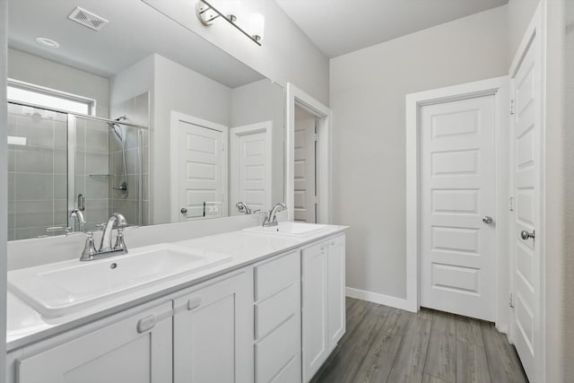 2321 Spring Side Dr, Royse City, TX 75189 - bathroom featuring a stall shower, double vanity, wood finished floors, and baseboards
