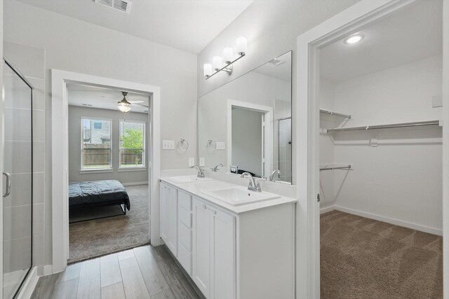 2321 Spring Side Dr, Royse City, TX 75189 - full bath featuring a stall shower, a walk in closet, double vanity, a ceiling fan, and baseboards
