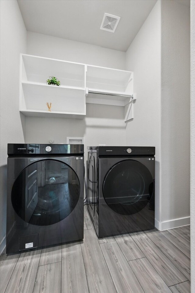 2321 Spring Side Dr, Royse City, TX 75189 - laundry room with separate washer and dryer, wood finished floors, and baseboards