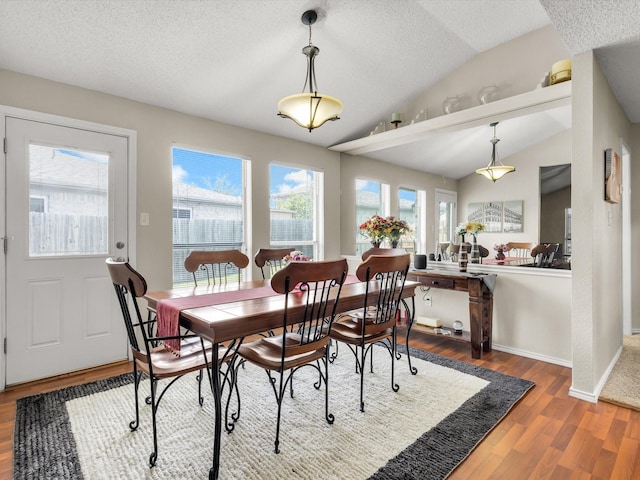 10117 High Bluff Dr, Fort Worth, TX 76108 - dining area featuring vaulted ceiling, wood finished floors, a textured ceiling, and baseboards