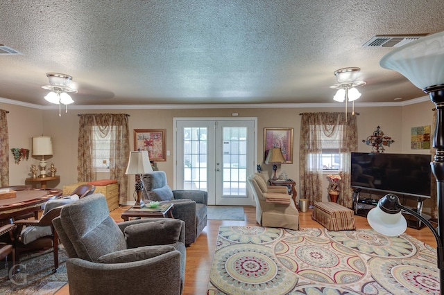 3415 Glasscock Ave, Bossier City, LA 71112 - living room featuring a ceiling fan, light wood-type flooring, plenty of natural light, a textured ceiling, and ornamental molding