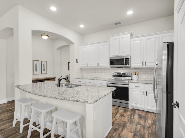 11716 Pistachio Trl, Fort Worth, TX 76108 - kitchen with stainless steel appliances, a sink, dark wood-type flooring, arched walkways, and recessed lighting