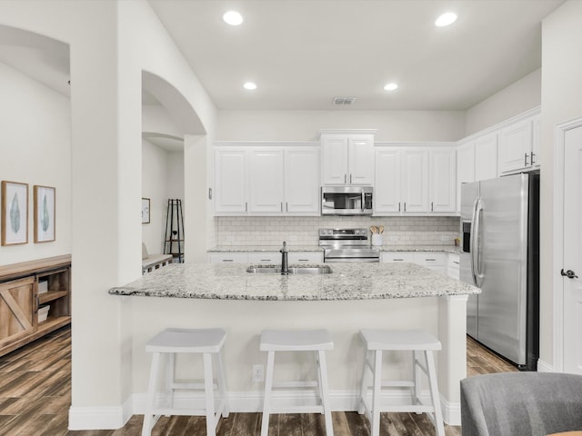 11716 Pistachio Trl, Fort Worth, TX 76108 - kitchen featuring stainless steel appliances, a sink, dark wood-style flooring, decorative backsplash, and white cabinetry
