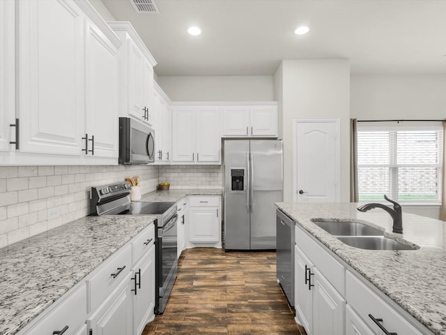 11716 Pistachio Trl, Fort Worth, TX 76108 - kitchen featuring appliances with stainless steel finishes, a sink, white cabinets, recessed lighting, and light stone countertops